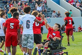 Port Huron High School players celebrate a touchdown with teammates during Victory Day